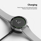 Galaxy Watch 4 Classic 46mm | Bezel Styling - Smartwatch with Ringke bezel styling charging on a wireless dock.
