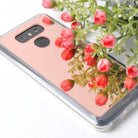 LG G6 Case | Mirror - Rose gold reflective phone case reflecting a bouquet of small pink flowers on a white surface.