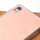 Xperia Z5 Premium Case | Mirror - Rose Gold - Rose gold mirror phone case with clear bumper on a wooden surface.