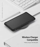 Galaxy S10 Case | Fusion-X Design - Black phone case on a wireless charging pad next to a white keyboard and notebook.