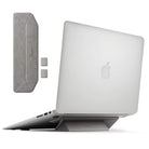 Laptop Stand - A grey foldable adhesive laptop stand attached to the base of a silver laptop, with extra pads shown.