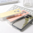 LG G6 Case | Mirror - Three reflective mirror phone cases in gold, rose gold, and silver stacked on a white keyboard.