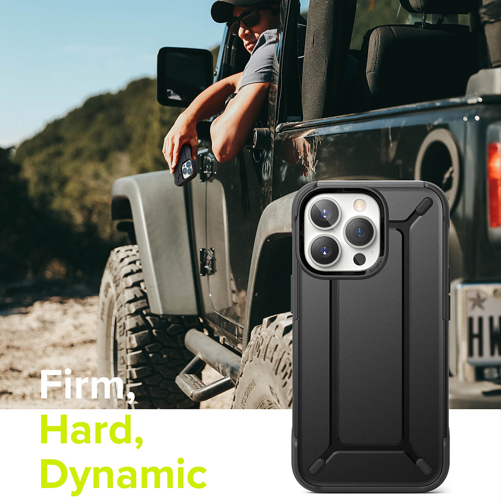 iPhone 13 Pro Case | DX - Black rugged phone case shown in foreground with a person in an off-road vehicle in the background.
