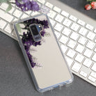 Galaxy S9 Plus Case | Mirror - Silver - Silver mirrored phone case reflecting purple flowers on a white keyboard.