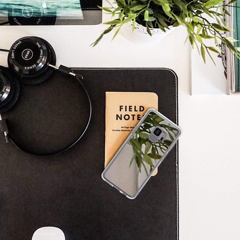 Galaxy S9 Case | Mirror - Silver - Reflective silver phone case on a desk with headphones, a notebook, and a plant.