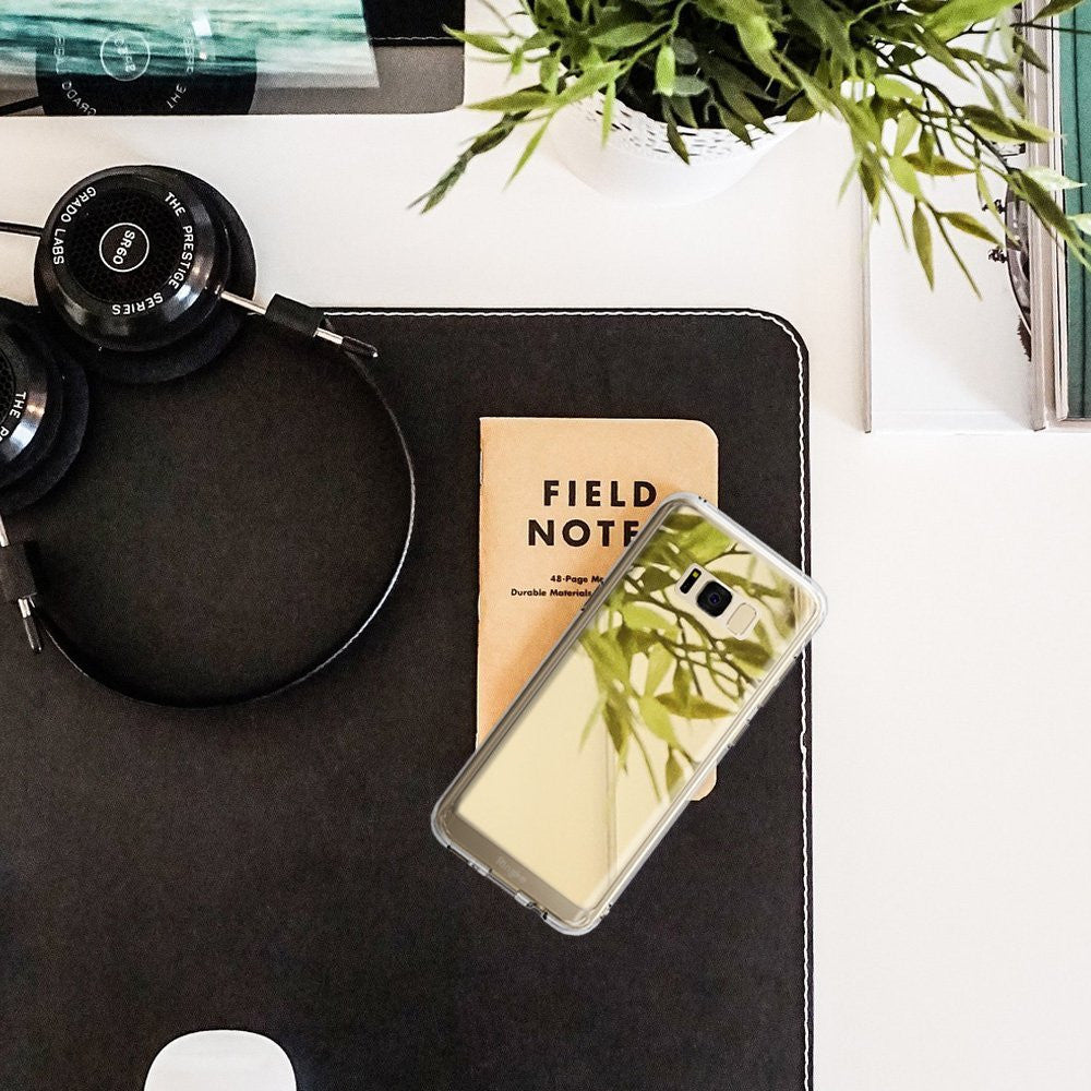 Galaxy S8 Case | Mirror - Reflective phone case on a desk with headphones, a notebook, and a plant.