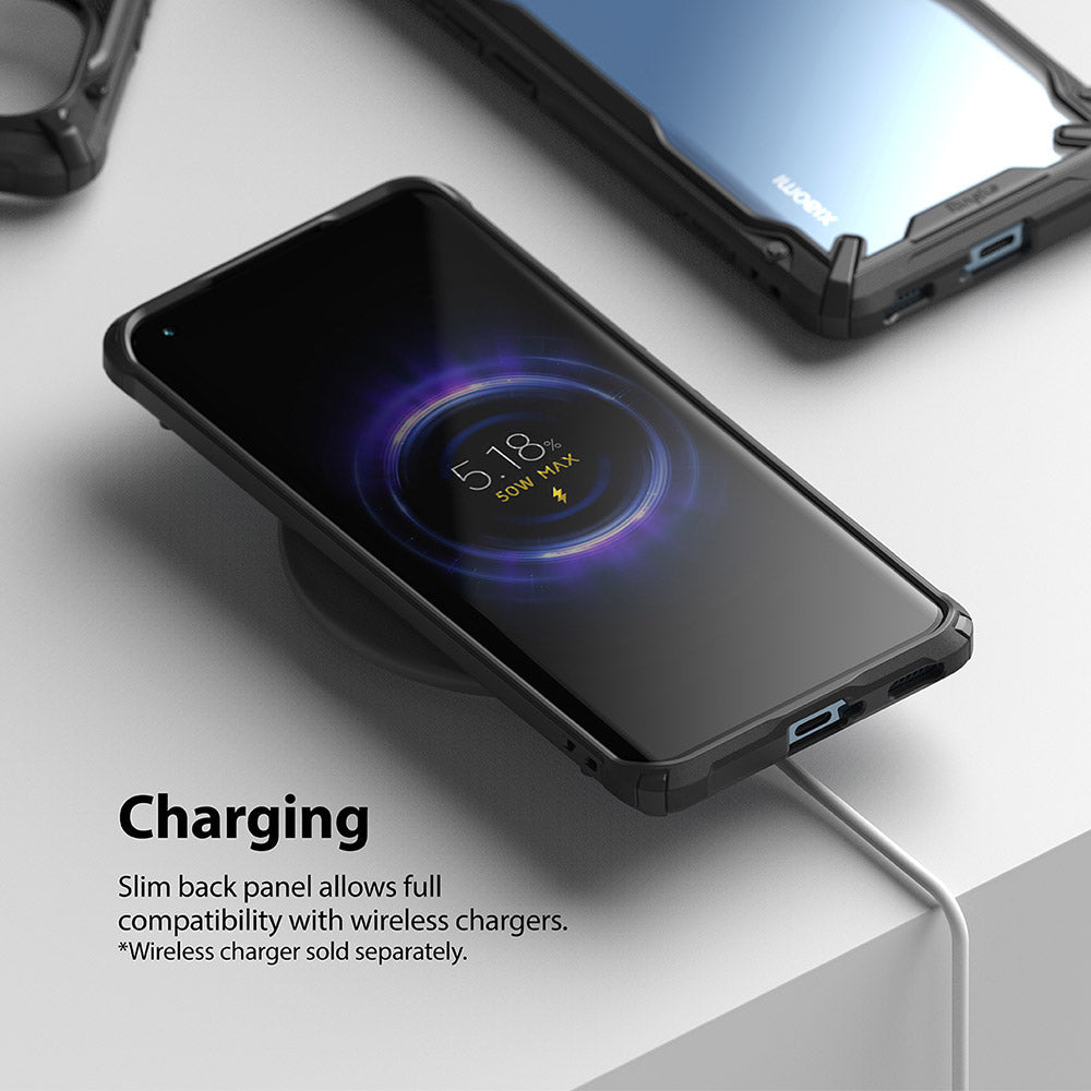 Mi 11 Case | Fusion-X - Mi 11 phone in a black Fusion-X case wirelessly charging on a pad with a 50W charging indicator.