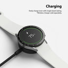 Galaxy Watch 5/4 40mm | Bezel Styling - Smartwatch with black tachymeter bezel styling charging on a wireless dock at 75%.