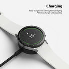 Galaxy Watch 5 / 4 (40mm) | Bezel Premium Styling - A smartwatch with a black bezel ring charging on a wireless dock.