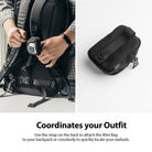 Mini Pouch | Block - A person attaches a small black textured pouch to a backpack strap, with a close-up view of the pouch.