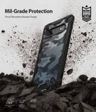 Galaxy S10 Case | Fusion-X Design - Camouflage Galaxy S10 phone case with black bumper, surrounded by flying dirt and debris.