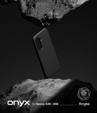 Galaxy A36 / A56 Case | Onyx - Black phone case floating between two jagged, dark rock formations against a black background.