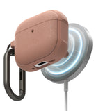 AirPods 5 / 4 Case | Onyx Magnetic - Textured rose-gold AirPods 4 case magnetically attached to a wireless charger with a black carabiner.