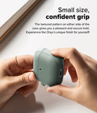 AirPods 5 / 4 Case | Onyx Magnetic - Hands holding a sage green textured AirPods 4 case with side grip detailing.