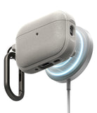 AirPods Pro 3 Case | Onyx Magnetic - Textured grey case magnetically charging on a glowing wireless dock with a carabiner.
