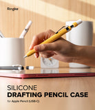 Apple Pencil USB-C Case | Silicone Drafting Pencil Case - Apple Pencil USB-C Case - Hand holding a yellow silicone drafting-style case over an Apple Pencil above a tablet.