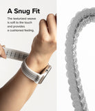 Apple Watch 42·41·40·38 mm | Sports Air Loop - A hand adjusting a white, textured, woven watch strap on a wrist.
