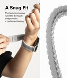 Apple Watch 49·46·45·44·42 mm | Sports Air Loop - Apple Watch Sports Air Loop - Hands adjusting a textured, grey woven watch band on a wrist with a close-up of the weave.