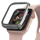 Apple Watch Series 6 / 5 / 4 / SE (44mm) | Bezel Styling - A metallic bezel cover hovering above a pink Apple Watch.