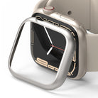 Apple Watch 9 / 8 / 7 (45mm) | Bezel Styling - A silver metallic bezel cover hovering over a beige Apple Watch.