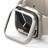 Apple Watch 9 / 8 / 7 (45mm) | Bezel Styling - A silver metallic bezel cover hovering over a beige Apple Watch.