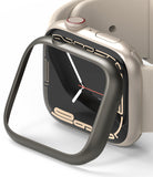 Apple Watch 9 / 8 / 7 (45mm) | Bezel Styling - A dark metallic bezel cover being placed over a beige Apple Watch.