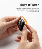 Apple Watch Series (45mm / 44mm) Case | Fusion Bumper - Hands attaching a flexible orange bumper case to an Apple Watch.