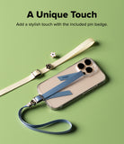 Band Buckle Rectangle Type Strap - A blue phone strap attached to a clear phone case, with a cream strap and flower pins nearby.