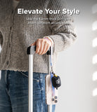 Band D Ring Hand Hook Strap - A person holding a suitcase handle with a phone and small pouch attached via a D-ring strap.