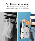 Day-Me Bag - Comparison of a single-use plastic bag and a reusable white bag with a dog print holding an orange.
