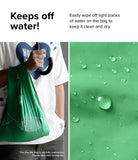 Day-Me Bag - A person holding a green water-resistant bag with water droplets beading on its surface.
