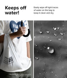 Day-Me Bag - A person holding a water-resistant bag with water droplets beaded on the fabric surface.