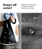 Day-Me Bag - A person holding a black bag and umbrella next to a close-up of water droplets beading on the fabric.