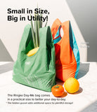Day-Me Bag - Green and orange reusable shopping bags with hidden gussets, filled with produce on a marble surface.