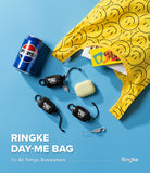 Day-Me Bag - Yellow smiley face tote bag with a Pepsi can, accessories, and branded black pouches on a blue background.