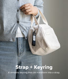 Holder Link Eyelet Keyring - A black fabric strap with a metal eyelet attached to the zipper of a white corduroy handbag.