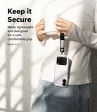 Holder Link Eyelet Keyring - A person holds a mug while a smartphone hangs from their wrist by a black fabric strap.