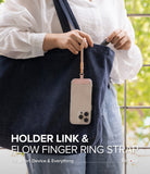 Holder Link Flow Finger Ring - A person holding a phone attached to a beige finger ring strap hanging from a denim tote bag.