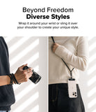 Holder Link Flow Shoulder Strap Y-Type - Black strap wrapped around a wrist and worn over the shoulder with a phone case.