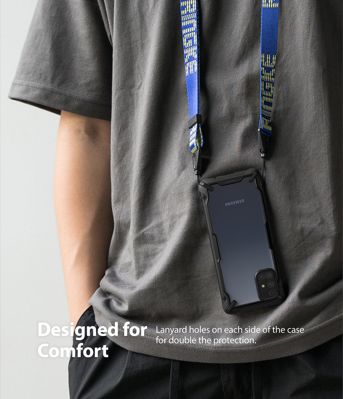 Galaxy M31s Case | Fusion-X - A phone in a black protective case hanging from a blue branded neck lanyard against a gray shirt.