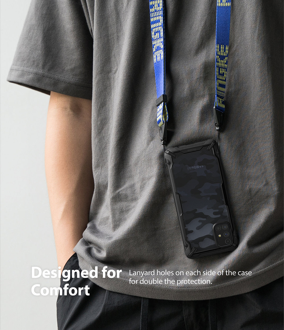 Galaxy M31s Case | Fusion-X - Camouflage phone case hanging from a blue branded neck lanyard worn by a person in a grey shirt.
