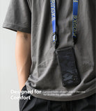 Galaxy M31s Case | Fusion-X - Camouflage phone case hanging from a blue branded neck lanyard worn by a person in a grey shirt.