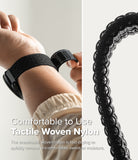 Forerunner 965 | Bezel Styling & Band - Close-up of a hand adjusting a black woven nylon watch band on a wrist.