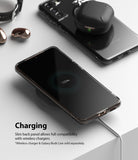Galaxy S21 Plus Case | Air - A Galaxy S21 Plus in a clear case wirelessly charging on a white surface with earbuds nearby.
