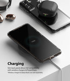 Galaxy S21 Plus Case | Fusion - Smartphone in a clear case wirelessly charging on a pad with earbuds resting nearby.