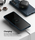 Galaxy S21 Plus Case | Onyx - A navy phone case on a wireless charger with 100% battery icon and earbuds charging on top.