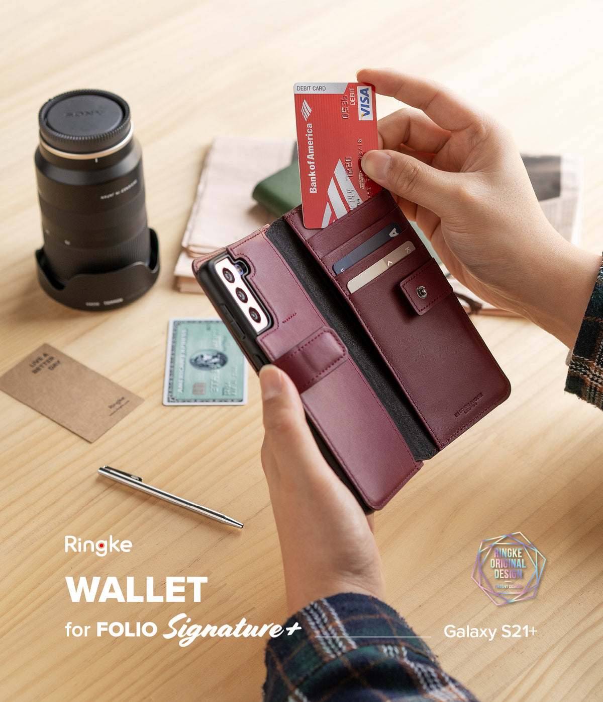 Galaxy S21 Case | Folio Signature+ - Hands holding a maroon leather wallet phone case with credit cards on a desk.