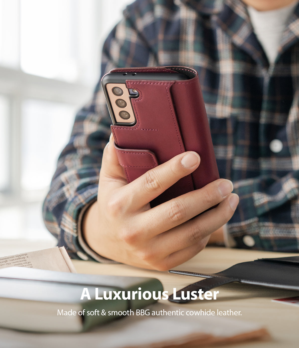 Galaxy S21 Case | Folio Signature+ - A hand holding a burgundy leather folio case for a Galaxy S21 phone.