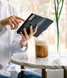 Galaxy S21 Case | Folio Signature+ - Person holding a black leather folio phone case at a marble cafe table.