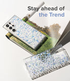 Galaxy S22 Ultra Case | Fusion Design - Two clear phone cases with blue floral patterns resting on a magazine.